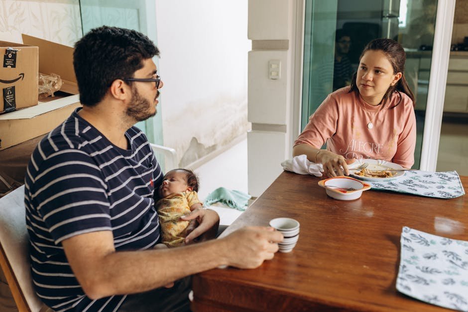 Exhausted caregiver sitting at kitchen table holding head in hands